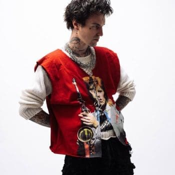 Jutes the singer 2025 press photo wearing a red custom david bowie sweater vest